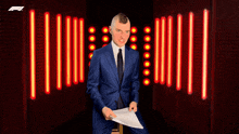 a man in a suit is holding a piece of paper