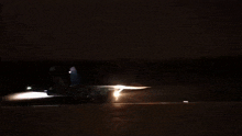 a jet is taking off from a runway at night with a bright light coming out of the tail