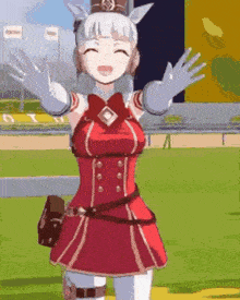 a girl in a red dress is standing on a field with her arms outstretched and smiling .