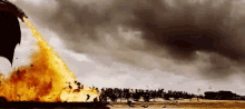 a dragon is flying through the air with flames coming out of its tail .