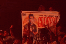 a group of people holding up a banner that says " miss you jonathan "