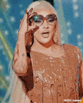 a drag queen wearing sunglasses and a brown dress