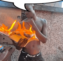 a shirtless man in nike shorts holds a burning book