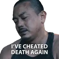 a man with a beard and a black tank top says " i 've cheated death again "