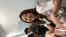 a woman in a white shirt is smiling in a room