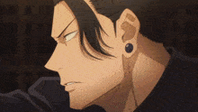 a close up of a man 's face with a black shirt and earrings