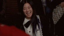 a woman with purple hair is laughing and wearing a bow tie