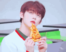 a young man is eating a slice of pizza with the words holy almost behind him