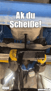 a picture of a man working under a car with the caption ak du scheiße !