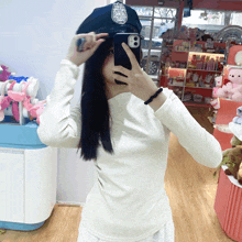 a woman wearing a police hat takes a selfie with her cell phone