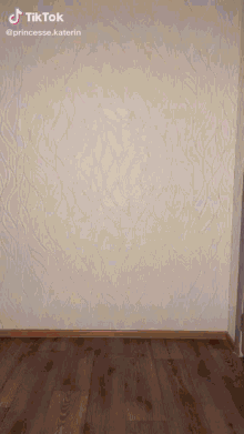 a tiktok video of a person dancing in front of a wall with a patterned wallpaper