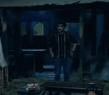 a man is holding a painting on an easel in a dark room .