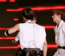 a man in a white shirt with a microphone on his neck is dancing on a stage