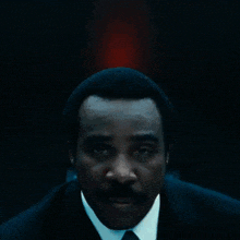 a man in a suit and tie has a blue lanyard around his neck with a key on it