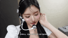 a woman wearing a headband and a microphone with korean writing on her face