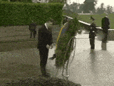 a man in a suit is putting a wreath on a stand