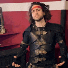 a man with a red headband is wearing a black armor