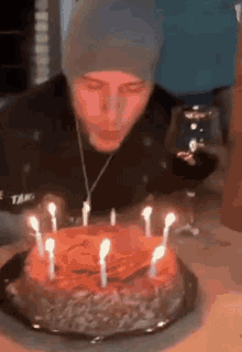 a person is blowing out candles on a cake .