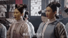 a group of women are standing next to each other in a room with chinese writing on them .