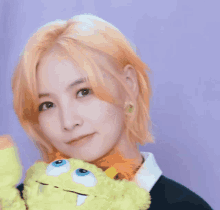 a woman with blonde hair is holding a stuffed animal .