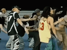 a group of people are dancing and one of them is wearing a yellow jersey with the number 13 on it