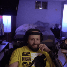 a man wearing headphones and a yellow shirt that says ab2 on it