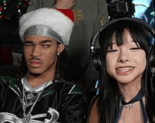 a man and a woman are wearing headphones and a santa hat