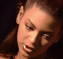 a close up of a woman 's face with her mouth open and earrings .