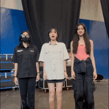 three girls are standing next to each other with one wearing a mask and a shirt that says ' a ' on it