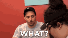 a man and a woman are looking at something and the man is saying what