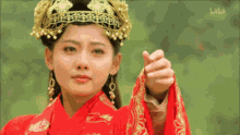 a woman wearing a red and gold costume and a crown