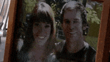 a man and a woman are posing for a picture together in a frame .