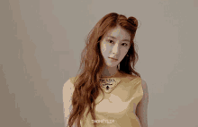 a woman with red hair wears a gold prada top