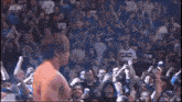 a man is standing in front of a crowd of people wearing a shirt that says aew .