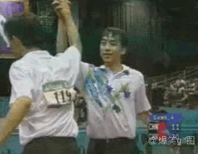 a man with the number 119 on his back is high fiving another man