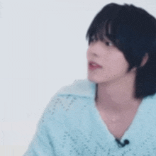 a blurry picture of a person wearing a blue sweater and a microphone .