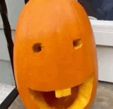 a pumpkin with a face carved into it and a hole in the middle of it .