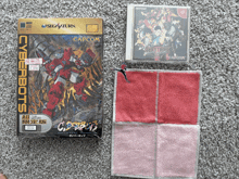 a video game called cyberbots sits on a carpet next to a towel