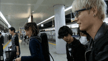 a group of people at a train station with the letter d on the bottom