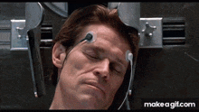 a man is laying in a hospital bed with his eyes closed and headphones on his head ..