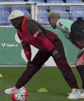 a man in a red jacket kicks a soccer ball