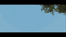 a plane is flying in the sky above a green and red building
