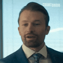 a man in a suit and tie with countdown written on the bottom right