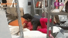 a man and woman are having sex in a room with a sign that says e 24