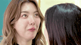 two women are looking at each other and one is making a face
