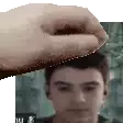 a pixel art of a hand holding a man 's head in front of a man 's face .