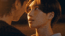 a man is touching another man 's forehead with his hands .