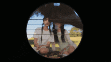 a blurry picture of two girls sitting next to each other in a field
