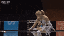 a woman in a wrestling ring with the word stardom on the bottom left