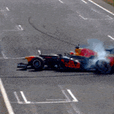 a red bull race car with smoke coming out of it